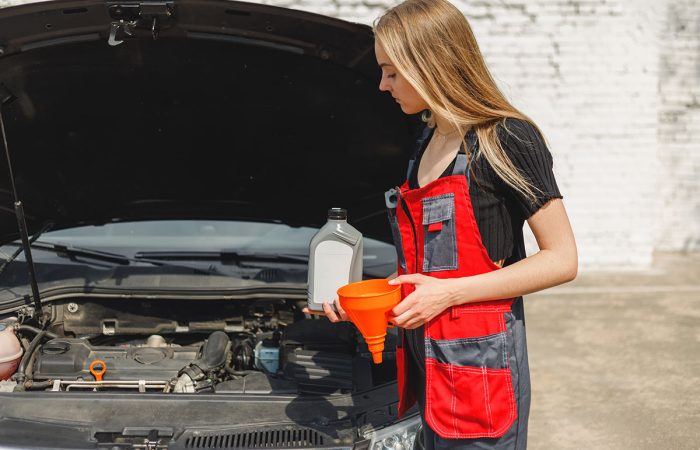 blond-woman-in-a-mechanic-s-uniform-holds-new-can